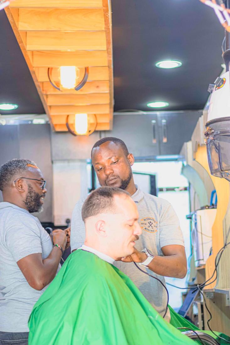 A barber finishing a fade with clippers