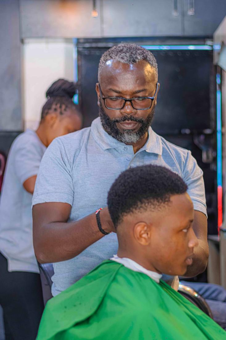 A barber shaping a client's hairline